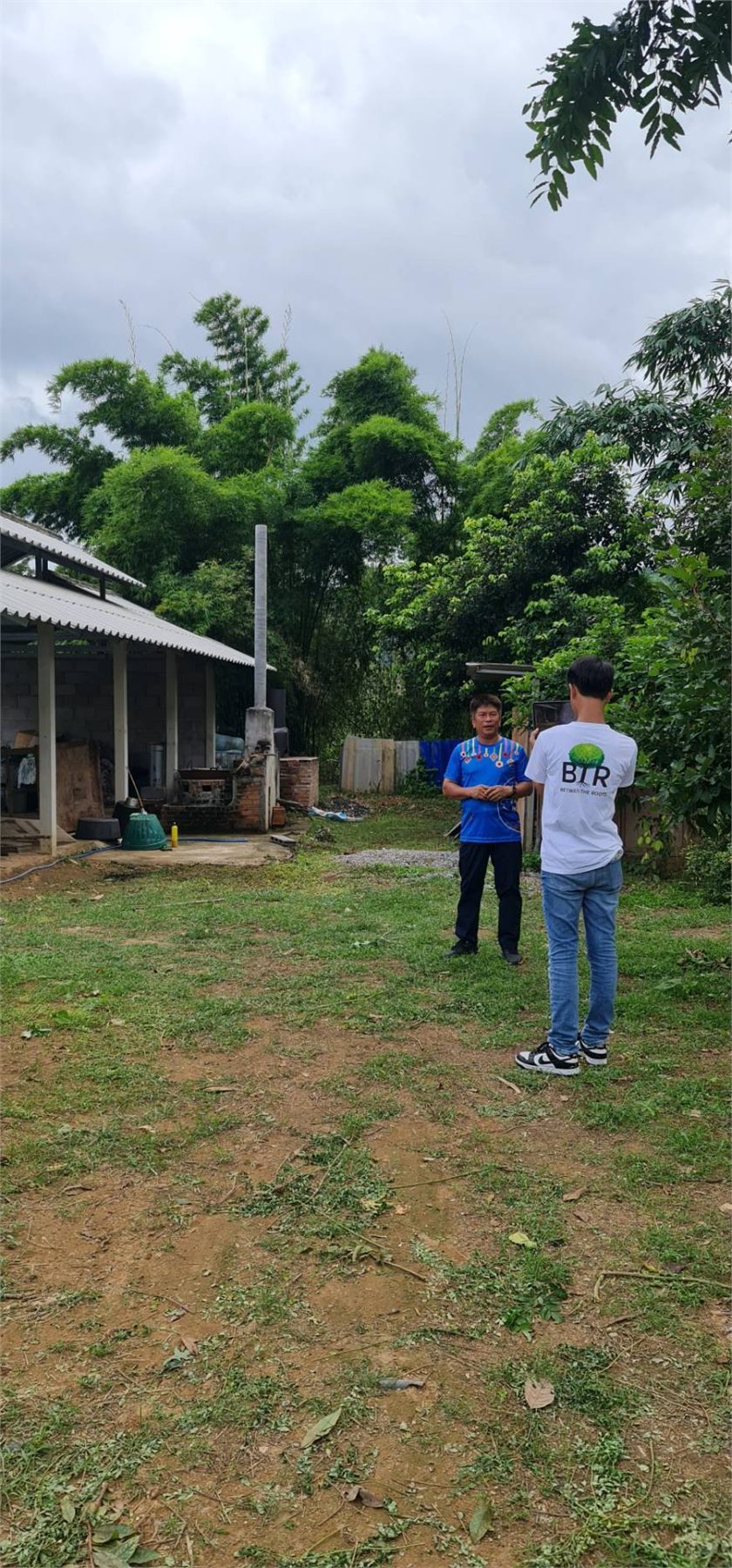 Two people standing in a yard at Pa Deng Village