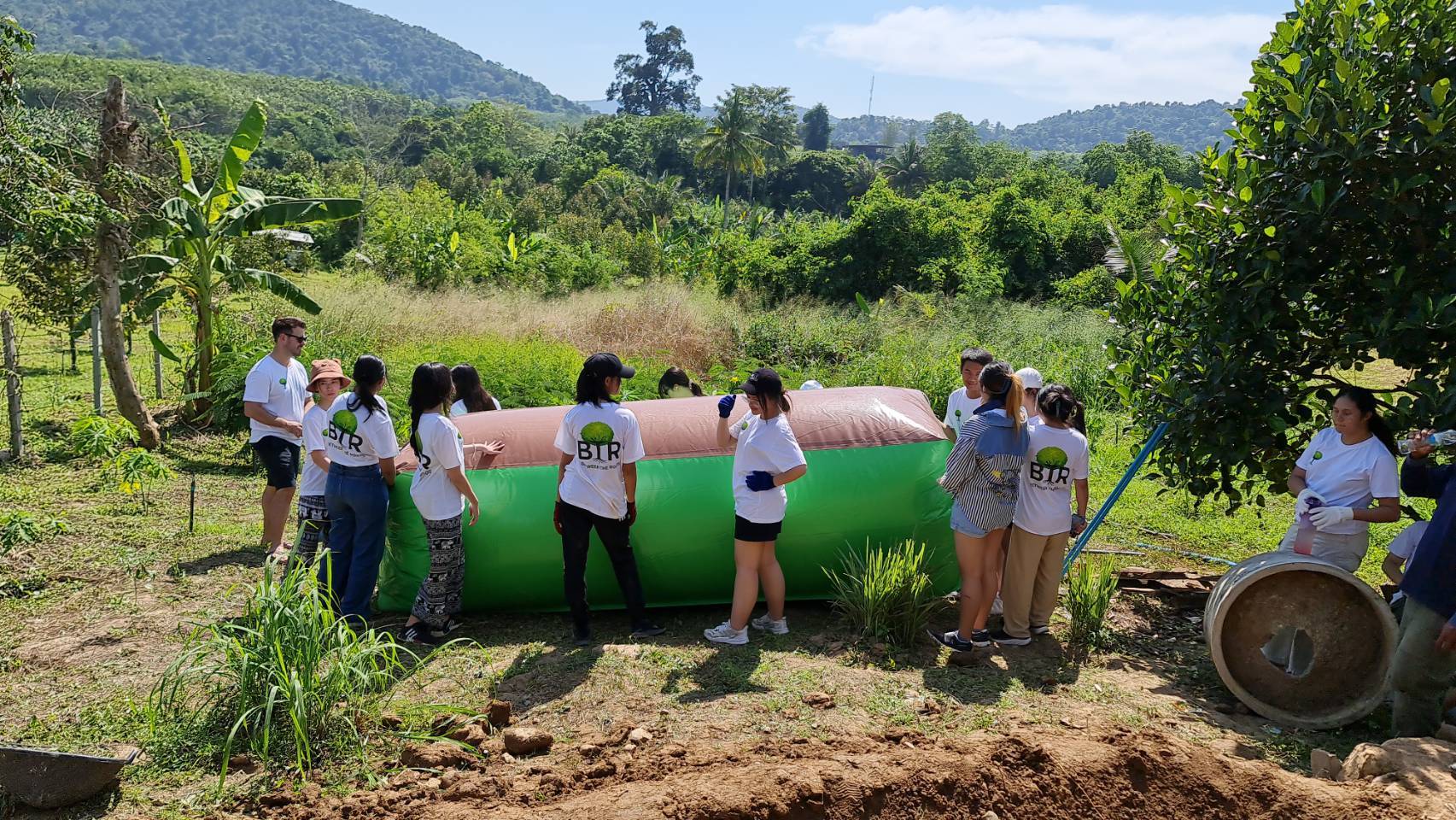 BTR volunteers beside an installed biogas balloon in a rural garden
